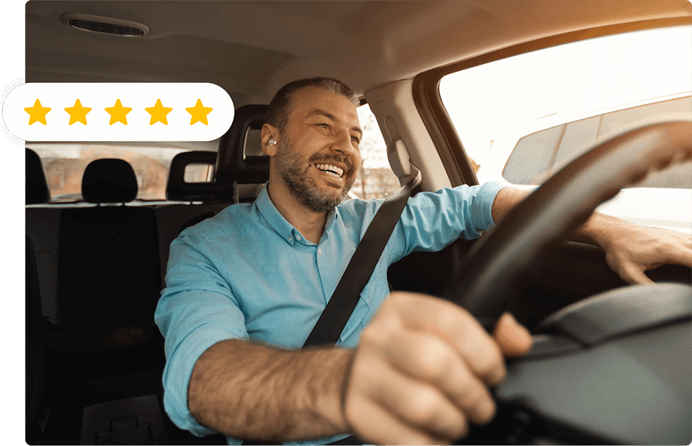 A smiling man driving his car.